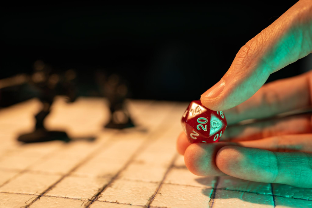 Mão segura dado de vinte faces sobre um mapa de RPG